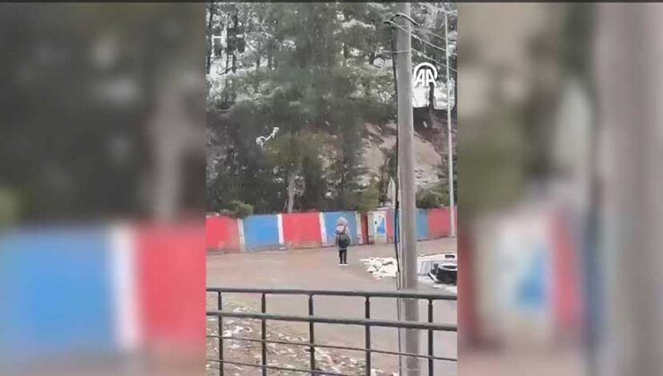 Karabük’te okula giderken İstiklal Marşı’nı duyan öğrenci, kar yağışı altında saygı duruşunda bulundu.